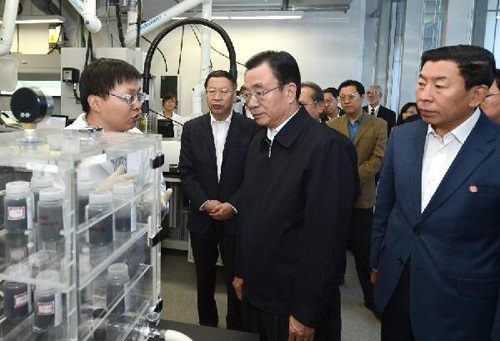 He Guoqiang (C), a member of the Standing Committee of Political Bureau of the Communist Party of China (CPC) Central Committee, talks with a staff member while visiting a lab of the National Institute of Clean-and-Low-Carbon Energy in Changping District, a suburb of Beijing, China, Oct. 17, 2012. (Xinhua/Ma Zhancheng)