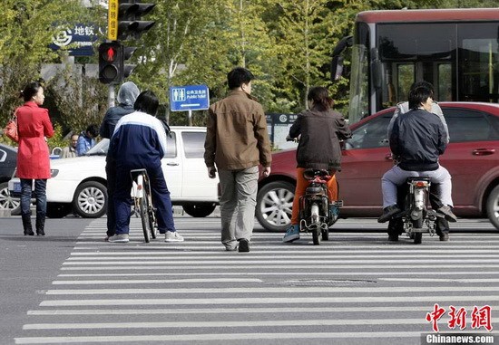 Pedestrians run a red light in groups of three and four at a crossroad in Beijing on Oct. 16, 2012. (CNSPHOTO/ Li Huisi)