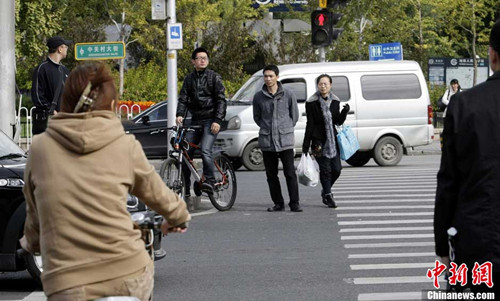 People run a red light in groups of three and four at a crossroad in Beijing on Oct. 16, 2012. (CNSPHOTO/ Li Huisi)