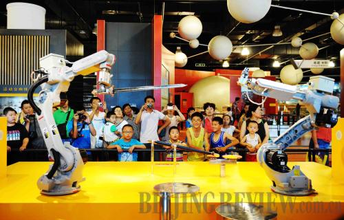 FUN SCIENCE: Children watch two robots fencing at the Heilongjiang Science and Technology Museum in Harbin, northeast China's Heilongjiang Province, on July 24 (WANG JIANWEI)