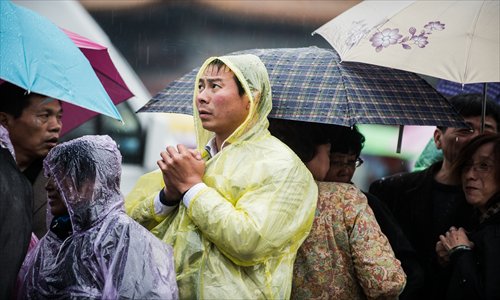 A man holds his hands to keep warm in the rain at Tiananmen Square Sunday. Photo: Li Hao/GT 