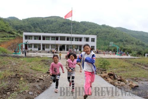 NEW SCHOOL, NEW HOPE: Children run joyously outside the newly built Dream School in Jiayan Village in Nayong County, Guizhou Province (LI JIAN) 