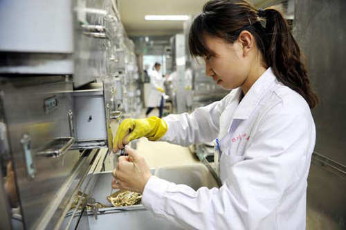 A staff member collects medicine for patients at a TCM hospital in Yinchuan, Ningxia Hui autonomous region, Oct 22, 2012. [Photo/Xinhua]  