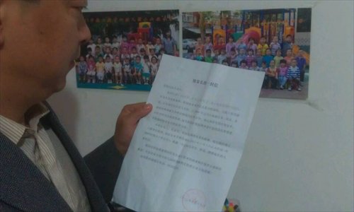 Feng Digang reads a letter sent by his son's kindergarten, informing parents the school will close for two years for reconstruction. (Photo: Courtesy of Feng)