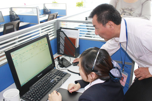 From top: Housekeeper Shi Jinmei trims the nails of Cai Guisan, in Suzhou, Jiangsu province. Lu Zhong (right), deputy director of the Jujiale service center, checks an employee's computer management system. Photos by Zhou Furong / China Daily