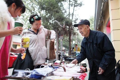 Centenarian Wang Zhenrong sells shoe insoles on Beijing's streets. Hou Shaoqing / for China Daily