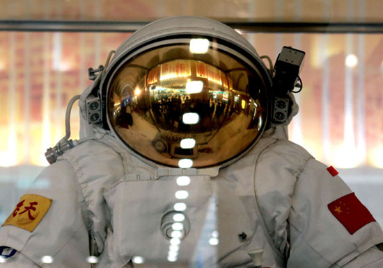 A group of visitors are reflected on a spacesuit helmet during an exhibition featuring China's achievements over the past decade at the Beijing Exhibition Center on Wednesday. Feng Yongbin / China Daily