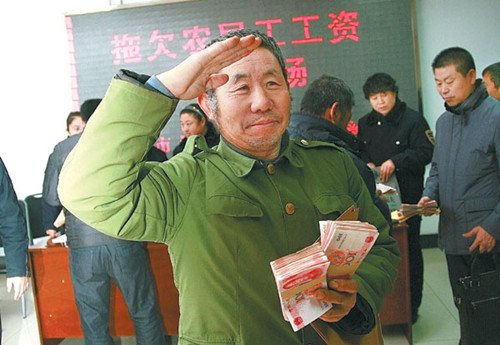 A migrant worker salutes government officials after he and 76 others received a total of 2.5 million yuan ($400,000) in overdue wages, thanks to the help of labor supervisors in Chaoyang, Liaoning province, this year. LI SONGJUAN / XINHUA