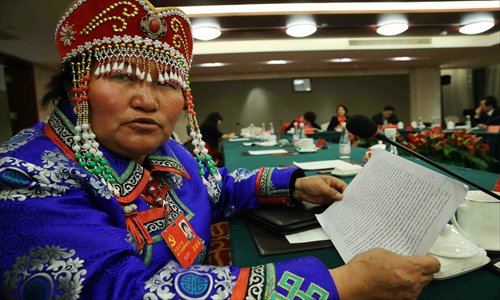 A delegate to the 18th Party congress from a minority ethnic group in Qinghai Province shows her speech in Mongolian Sunday. Photo: Xinhua 