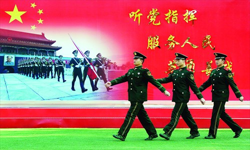 Members of Chinese Armed Police march past a sign saying Serve the Party and the People at their barracks beside the Great Hall of the People in Beijing on Monday. Photo: AFP 