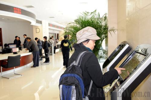 EASY ACCESS: A resident checks information on a self-service machine at an administrative service center in Beijing's Xicheng District on April 18 (ZHANG XU)  