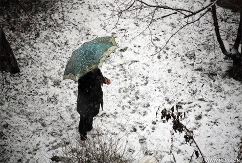 A citizen walks in snow in Jilin City, northeast China's Jilin Province, Nov. 12, 2012. A cold front is sweeping across the country's northern areas, bringing heavy snow and blizzards. (Xinhua) 