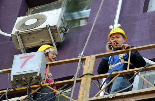 Gao Qiang, a migrant worker at a construction site in Beijing, realizes that a smartphone is an indispensable part of his daily life. Zhu Xingxin / China Daily 