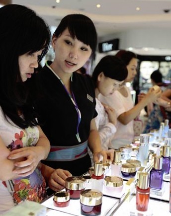 A sales representative assists a shopper at China Duty Free Group Co Ltd's outlet in Sanya, Hainan province. [Photo/China Daily] 