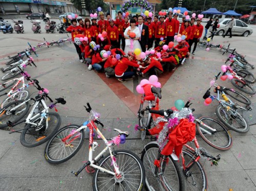 A newly-wed couple poses with their relatives among bicycles in Baise city, Guangxi province on Nov 25, 2012. Since National Day on Oct 1, bicycle weddings have become popular in the old revolutionary city. Young people have opted for two wheels over four