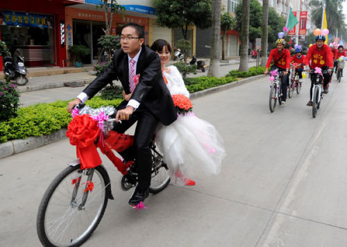 A newly-wed couple is followed by their relatives on bicycles in Baise city, Guangxi province, on Nov 25, 2012. Since National Day on Oct 1, bicycle weddings have become popular in the old revolutionary city. Young people have opted for two wheels over fo