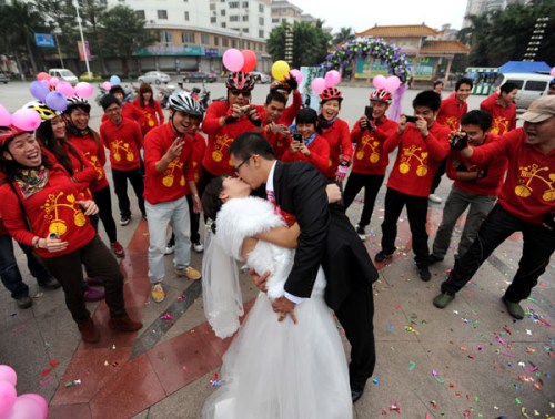 A bicycle wedding sealed with a kiss in Baise city, Guangxi province on Nov 25, 2012. Since National Day on Oct 1, bicycle weddings have become popular in the old revolutionary city. Young people have opted for two wheels over four for environmental reasons and the added romance of love-on-a-bike. [Photo by Luo Zhiken/Asianewsphoto]