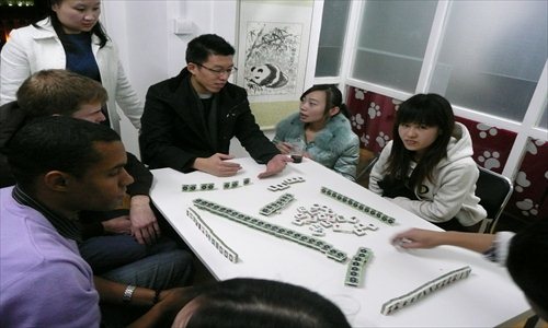 Westerners watch and learn how to make dumplings and the skills and tactics of playing mahjong.