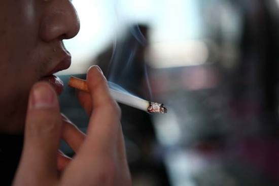 A man smokes a cigarette in Beijing in January 2011. [Photo/China Daily]