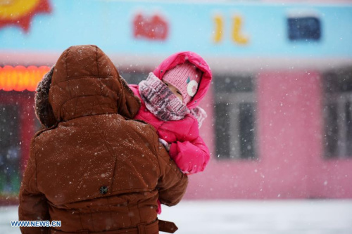 A little girl is sent to a kindergarten as snow hits Harbin, capital of northeast China's Heilongjiang Province, Nov. 28, 2012. Cold air front moving eastward will sweep China's northern regions during the next few days, bringing strong winds and big temperature drops, the National Meteorological Center (NMC) forecast on Wednesday. (Xinhua/Wang Kai) 