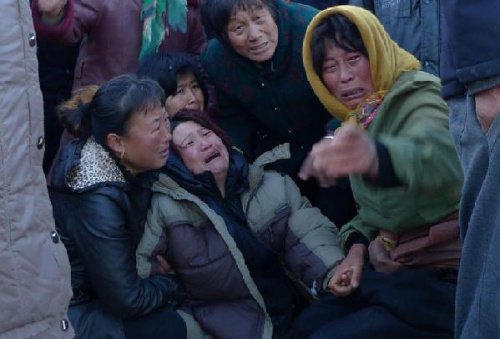 Relatives of victims are seen at a port near which a fishing boat capsized and sank in Dalian, northeast China's Liaoning Province, Nov. 28, 2012. The only person who was saved was in normal condition and under observation at a local hospital. (Xinhua)