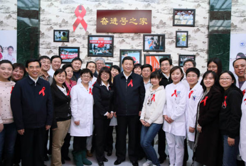 Xi Jinping, general secretary of the Communist Party of China (CPC) Central Committee, poses for a group photo with medical experts, volunteers and representatives of non-governmental organizations while visiting a community clinic on eve of the World Aids Day in Beijing, capital of China, Nov. 30, 2012. (Xinhua/Lan Hongguang)