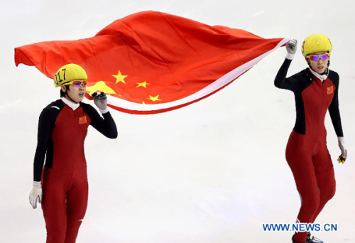 Wang Meng of China and her teammate Fan Kexin celebrate victory after the women's 500m final during the ISU Short Track World Cup speed skating competition in Shanghai, China, on Dec. 9, 2012. Wang won the gold medal with a time of 43.743 seconds.(Xinhua/Fan Jun)