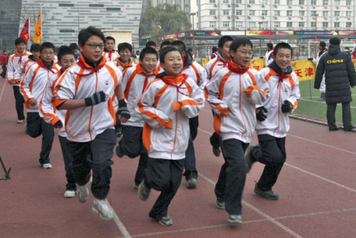 Photo taken on Dec 7, 2012 shows students running in a stadium at a ceremony marking the start of the winter long-distance running activities for students in Beijing. [Photo/Xinhua]