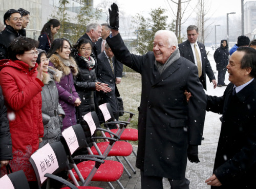 Former United States president Jimmy Carter waves to a group of people before taking a picture with them in Beijing on Wednesday. Carter visited Peking University on Wednesday and made a speech at a seminar organized by the university and The Carter Center. [Photo by KUANG LINHUA / CHINA DAILY]