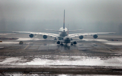 A plane is ready for takeoff on the parking apron covered with snow at the Beijing Capital International Airport in Beijing on Dec 12, 2012. [Photo/Xinhua]