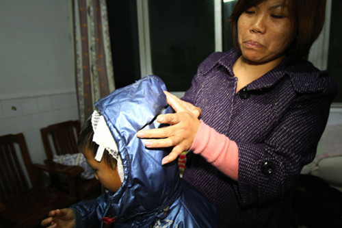 A mother weeps as she looks at wounds her son, Wei Xiang, suffered during a knife attack on Sunday in Guangshan county, Henan province. WANG ZHONGJU / FOR CHINA DAILY