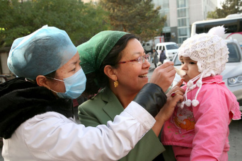 A medical worker gives a polio vaccine to a child in Hami prefecture in Northwest China's Xinjiang Uygur autonomous region. CAI ZENGLE / FOR CHINA DAILY