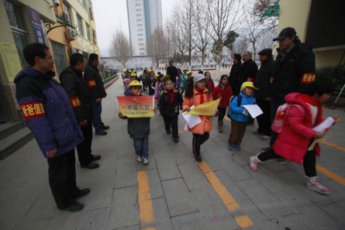 Fathers stand at the shcool gate of Shungeng Primary School to protect students in Jinan, Shandong province, Dec 20. The school set up the Guards of Fathers to maintain school security. [Photo/Asianewsphoto]