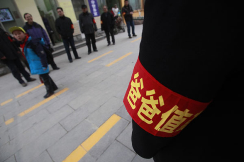 Fathers stand at the shcool gate of Shungeng Primary School to protect students in Jinan, Shandong province, Dec 20. The school set up the Guards of Fathers to maintain school security. [Photo/Asianewsphoto]