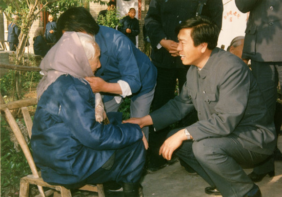 File photo shows Zhang Dejiang (R), then working in the Ministry of Civil Affairs, visits a centenarian woman during his investigation in rural nursing homes in central China's Henan Province. (Xinhua)