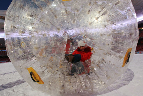 A tourist plays in a big balloon at the Bird's Nest, the National Stadium, in Beijing on Sunday. CUI MENG / CHINA DAILY