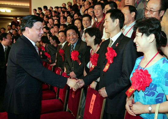 In this file photo taken on July 19, 2004, Liu Yunshan (L, front) meets representatives attending a commendation ceremony of young and middle-aged Chinese literary and art workers with supreme virtue and artistic achievements at the Great Hall of the Peop