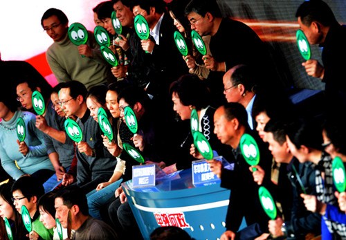 Members of the audience raise sad-face cards to show their dissatisfaction with the local government's performance at this year's third TV broadcast of Wuhan offi cials' annual briefi ng on their work on Dec 19. [China Daily]