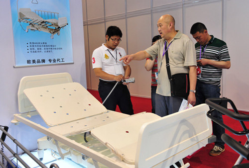 SERVICES FOR THE ELDERLY: A visitor inquires about an electric nursing bed at the First China International Senior Services Expo held in Shanghai in May 2012 (ZHANG JIANSONG)