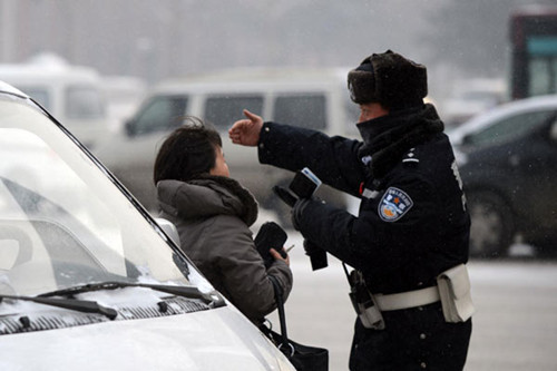 Atraffic police, right, talks to a driver running a red light in Changchun, Northeast China's Jilin province, Jan 1, 2012.  [Photo/Xinhua]