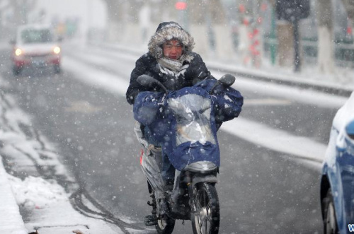 A citizen rides in snow on a street in Hangzhou, capital of east China's Zhejiang Province, Jan. 4, 2013. A heavy snow hit many parts of Zhejiang on Friday. (Xinhua/Ju Huanzong) 