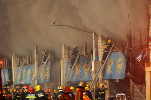 Firefighters try to put out fire at a farm produce wholesale market in Shanghai on Jan 6, 2013. [Photo/Xinhua] 