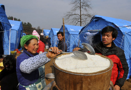 Local residents from nearby villages cook for mudslide victims at the makeshift relocation of the Gaopo village in Zhenxiong county of Zhaotong city, Southwest China's Yunnan province, on Jan 12, 2013. [Photo/Xinhua]