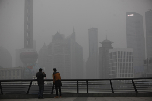 People visit the Bund in front of Pudong Lujiazui financial area on a hazy day in Shanghai Jan 16, 2013. [Photo/Agencies]