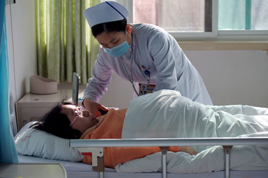 A nurse checks the blood pressure of Lu Yuanfang, who is pregnant and suff ers from spinal muscular atrophy, at the Aviation General Hospital in Beijing on Tuesday. [WEI XIAOHAO / CHINA DAILY]