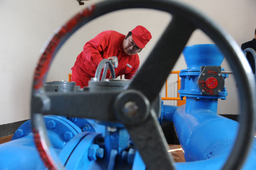 A worker at Sinopec Green Energy Geothermal Development carries out equipment repair work to the geothermal heating system in Xiongxian county, Baoding, Hebei province in January, 2010. [HU QINGMING / FOR CHINA DAILY] 