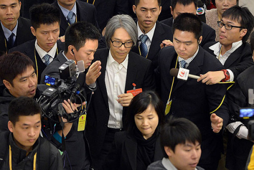 Stephen Chow, the Hong Kong comedian, film director and a political adviser to Guangdong province, is surrounded by reporters in the provincial capital, Guangzhou, on Friday. [Photo by Lin Guiyan / for China Daily]