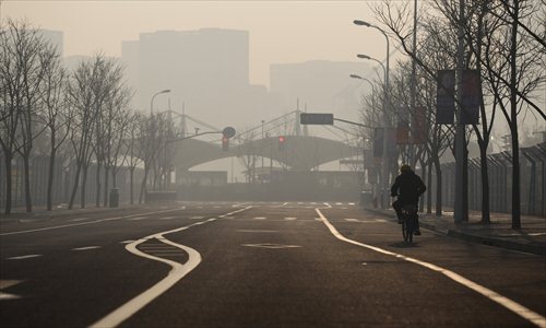 A bicyclist rides through the heavy smog in Huangpu district Wednesday, when the city's air pollution index hit a record high. Photo: Cai Xianmin/GT 