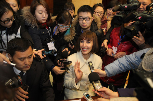 Kim Lee (center) speaks to media after a court ruling on her high-profile divorce at the Chaoyang District People's Court in Beijing on Sunday. The court granted Lee properties worth more than 12 million yuan ($1.9 million) and custody of her three daughters. [ZHU XINGXIN / CHINA DAILY]