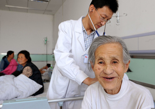 A doctor at a hospital in Shenmu county, Shaanxi province, performs a checkup on an elderly woman with pleural effusion, an accumulation of excess fluid surrounding the lungs. [China Daily]